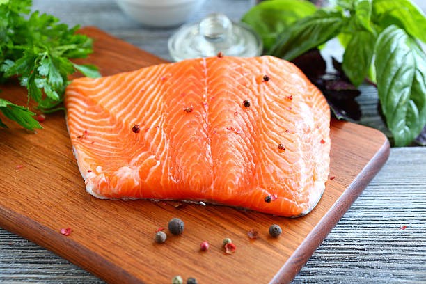 istock Red fish fillet with greens on a cutting board 530885597