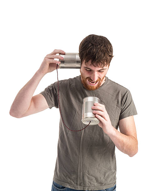 istock Young Man Talks into a Tin Can Telephone 530886659