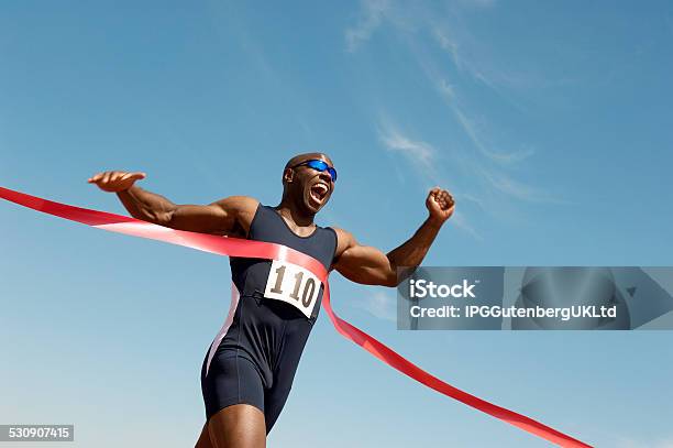 Runner Breaking Finish Line Tape Stock Photo - Download Image Now - Winning, Finish Line, Sports Race