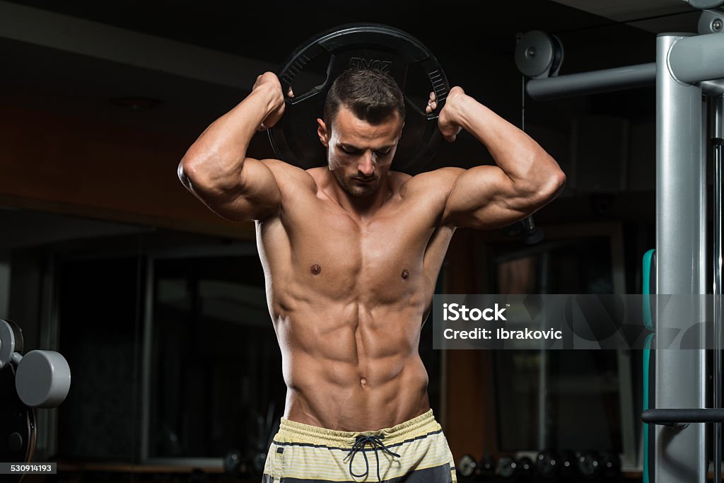Triceps Workout With Weight Young Athlete Exercise In The Gym - He Is Performing Triceps Exercises Abdominal Muscle Stock Photo