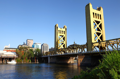 Sacramento, California skyline along the banks of the Sacramento River. The Tower Bridge links West Sacramento in Yolo County to the west. Sacramento is the capital city of the U.S. state of California