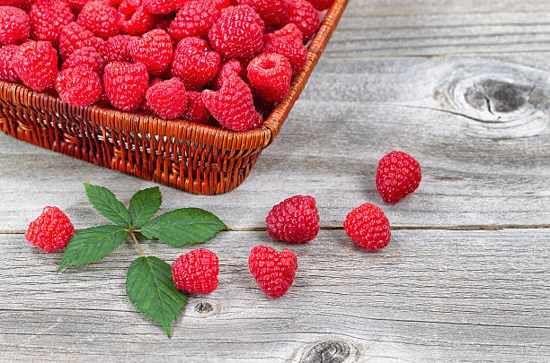 istock Basket Filled with Fresh Ripe Raspberries on Aged Wood 530916983