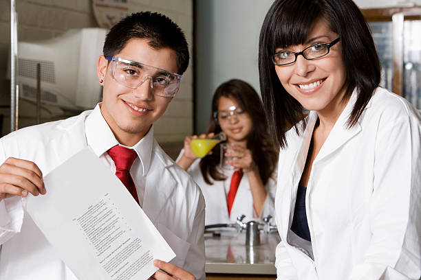 istock Professor With Student Holding Report In Lab 530917143