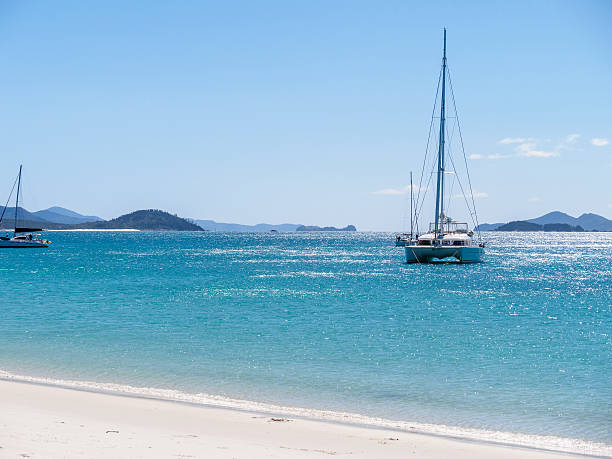 istock White catamaran on azure water against blue sky. 530919508