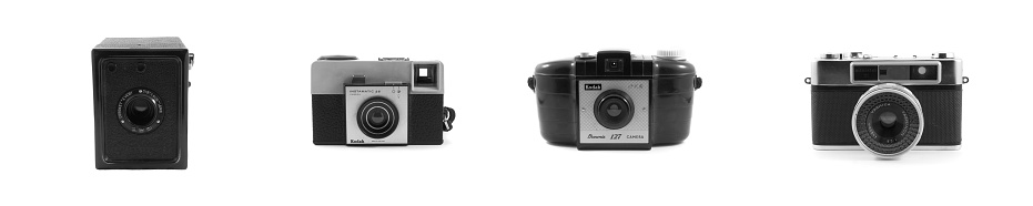 Vancouver, Canada - January 2, 2015: Black and white of four vintage cameras isolated on white backgrounds. Included are the Coronet Every, Kodak Brownie, Kodak Instamatic and Yashica Minister III. 