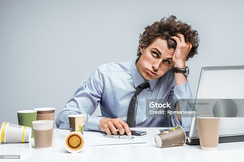 Distressed young manager man holds her head with hand Distressed young manager man holds her head with hand. Modern office man at working place, depression and crisis concept Occupation Stock Photo