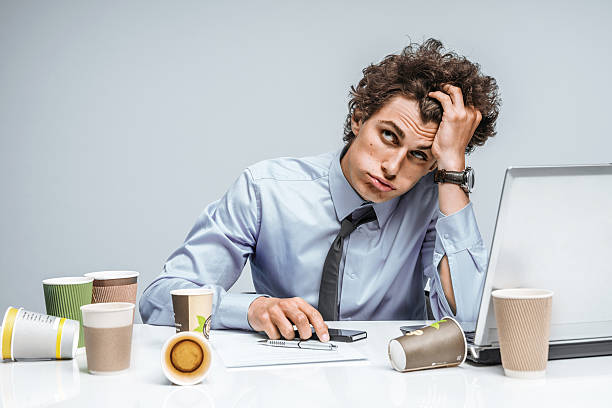 jovem angustiada gerente homem dá a sua cabeça com a mão - behavior office men sadness imagens e fotografias de stock