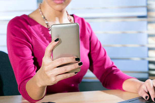 istock Woman holding a phone at work 530920730
