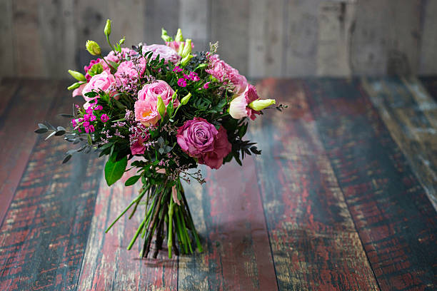 Rustic wedding bouquet with pink roses and Lisianthus flowers.