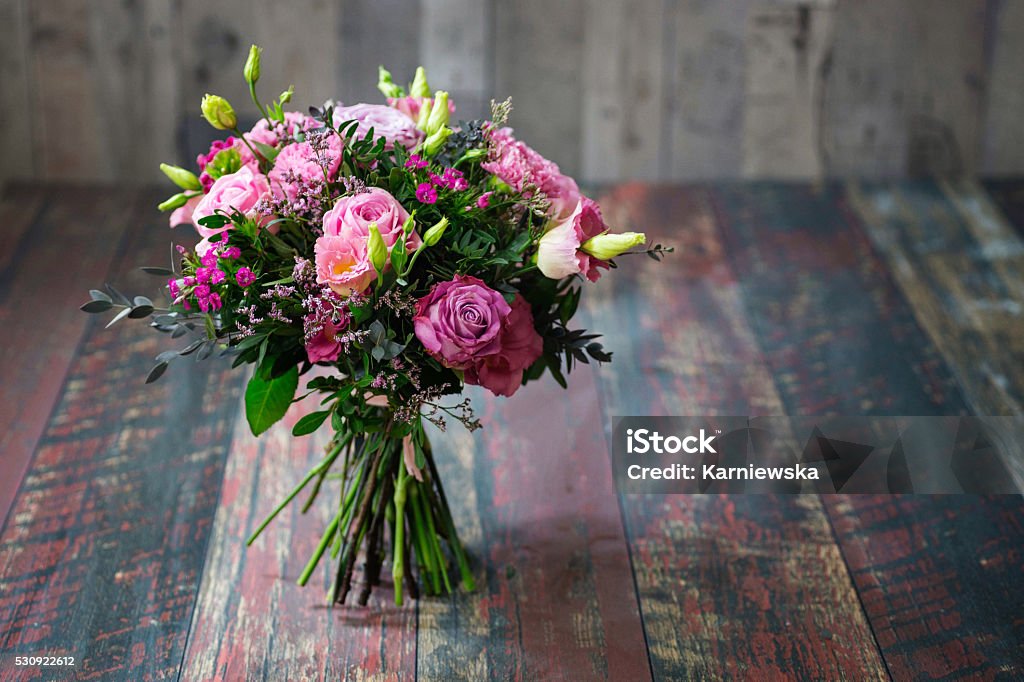 Rustic wedding bouquet with pink roses and Lisianthus flowers. Beautiful floral arrangement for Mother's or Valentine's Day. Bouquet Stock Photo
