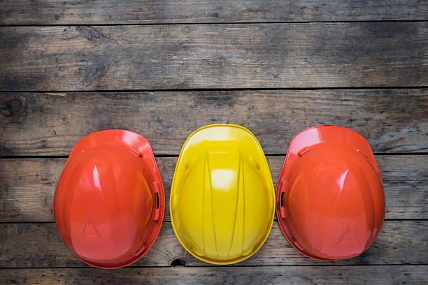 istock red and yellow helmets on the old wood table 530923560