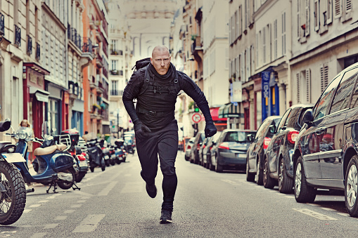 Bald white male jogging in black in Paris street