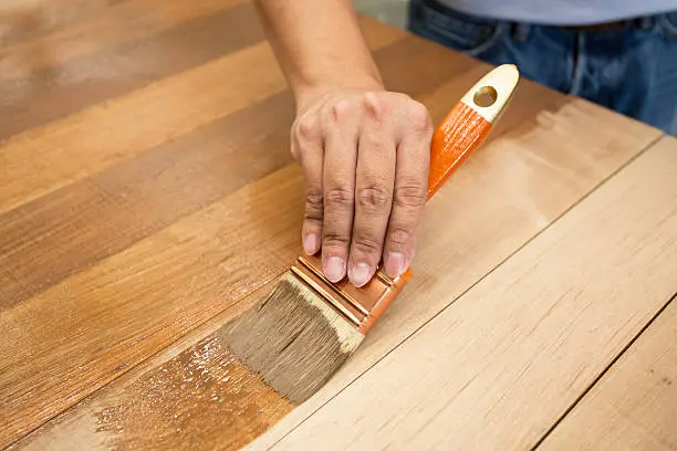 Photo of Applying protective varnish on a wooden furniture