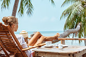 Young woman enjoys drinking coffee and coconut