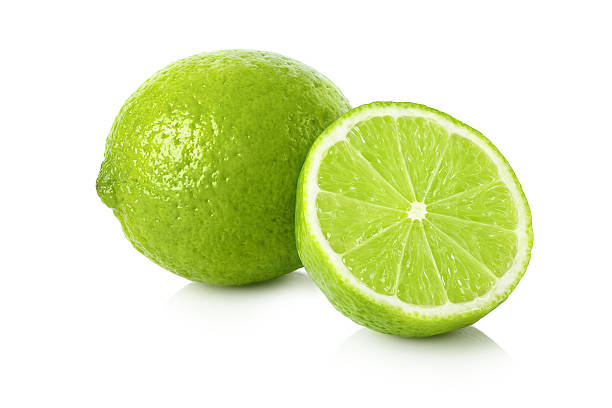 limón fresco con una media - limones verdes fotografías e imágenes de stock