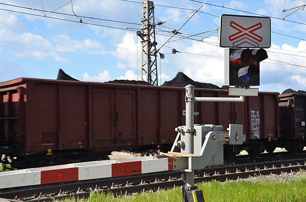 istock Stop sign, red lights on railway crossing, passing cargo train 530929870