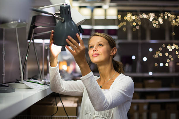 bonito, jovem mulher escolhendo a iluminação perfeita para o seu apartamento - light shop imagens e fotografias de stock