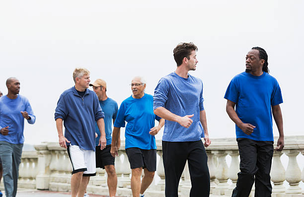 grupo de homens usando azul camisas, andar depressa - walking exercising relaxation exercise group of people imagens e fotografias de stock