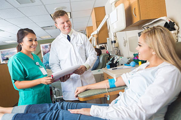 istock Doctor and nurse checking on patient while she donates blood 530930491
