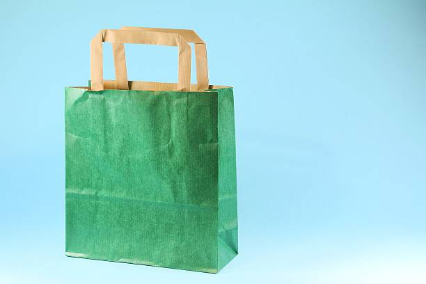 istock Green shopping bag on light blue background 530930804
