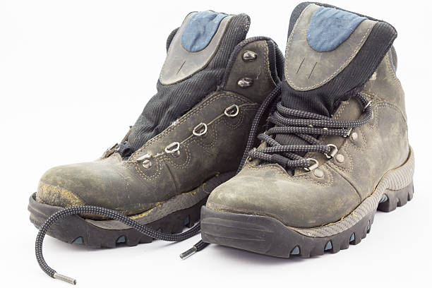 istock Old weathered and broken hiking boots isolated on white backgrou 530931474