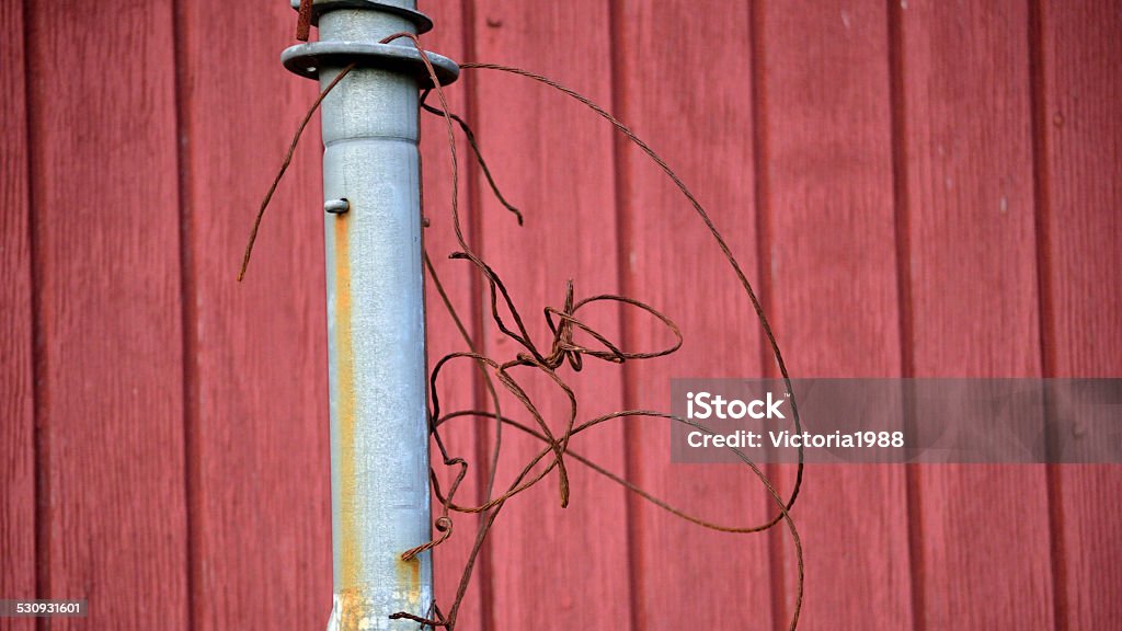Antenna pole with bent, rusty wire against red wall Old antenna pole with rusty, bent wire, against red wood plank wall Abstract Stock Photo