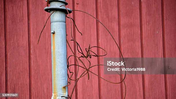 Antenna Pole With Bent Rusty Wire Against Red Wall Stock Photo - Download Image Now