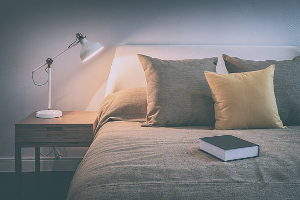 dormitorio acogedor interior con libro y una lámpara de lectura - hotel room bedding domestic room hotel suite fotografías e imágenes de stock