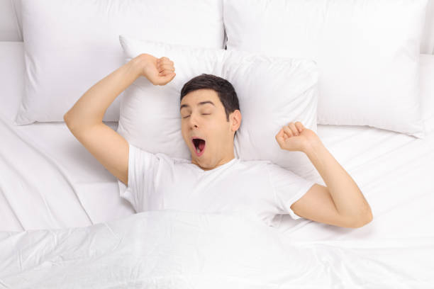 istock Rested man waking up in a bed 530932634