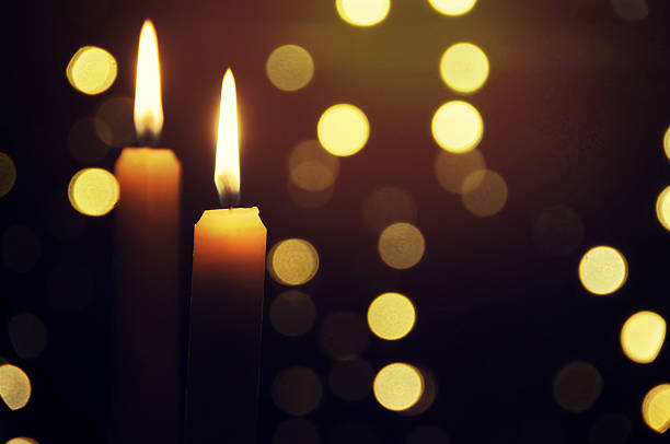 istock Candle with a flame brighter than the Christmas tree behind 530932988