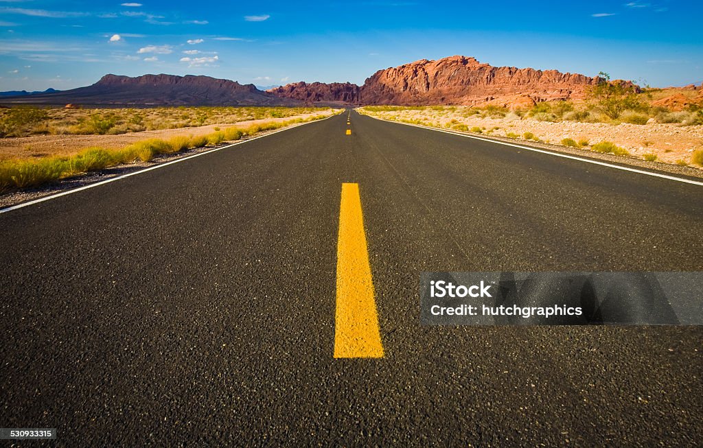 Road view towards mountains in desert Close up of road view at center line looking towards mountains in desert. Asphalt Stock Photo