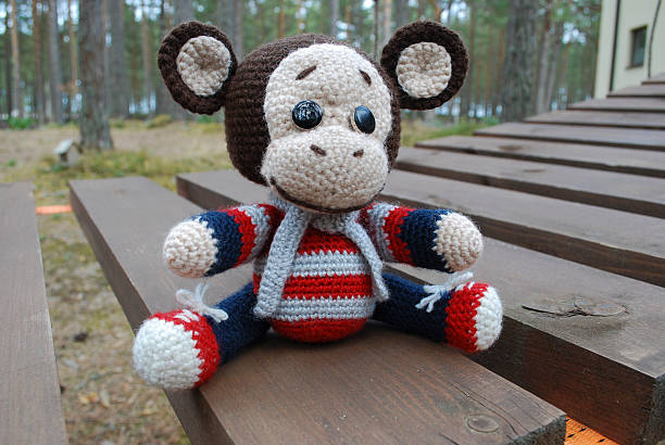 istock Toy monkey sitting on the wooden boards. 530933752