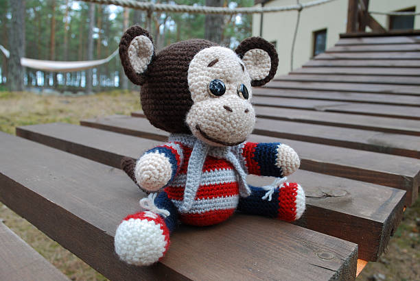 istock Toy monkey sitting on the wooden boards. 530933830