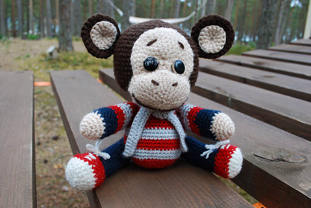 istock Toy monkey sitting on the wooden boards. 530933876