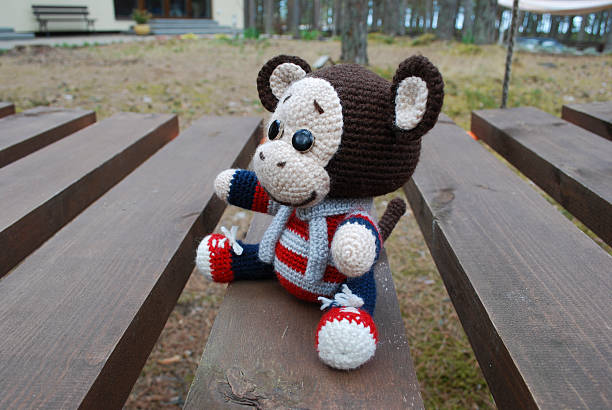 istock Toy monkey sitting on the wooden boards. 530933966