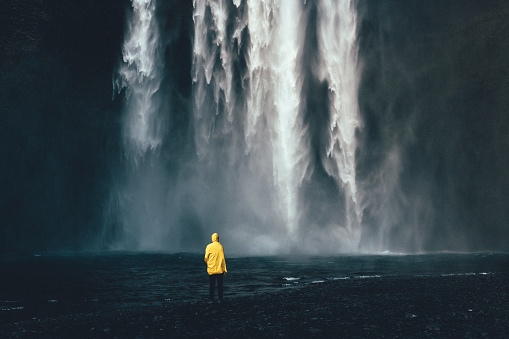 Man standing near the waterfall in Iceland