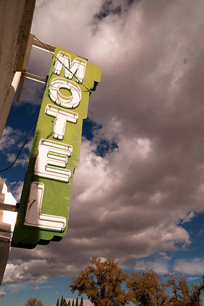 istock Neon Motel Sign Clear Blue Sky White Billowing Clouds 530937629