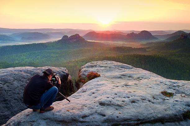 istock Professional photographer with tripod on cliff 530940074