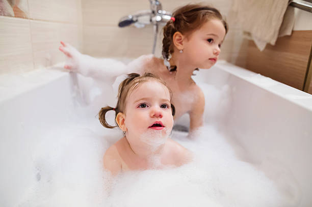istock Two little girls having bath with bubbles in bathtub 530940948