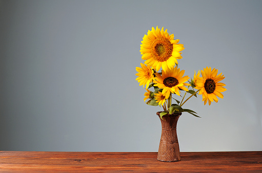 Sunflower in a ceramic vase on a wooden table