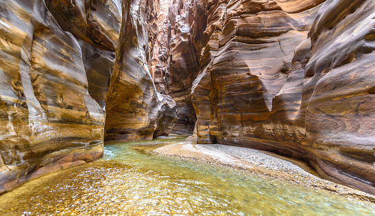 Wadi Bani Awf—one of Oman’s most challenging river gorges, one can swim in winding Snake Gorge. Some women swimming in distance.