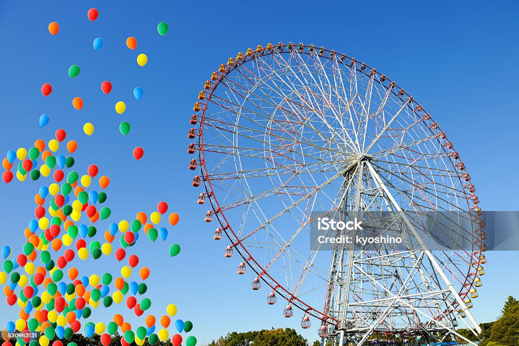 Ferris wheel with multicolored balloons moving up in clear sky Ferris wheel with multicolored balloons moving up in a clear sky. 2015 Stock Photo