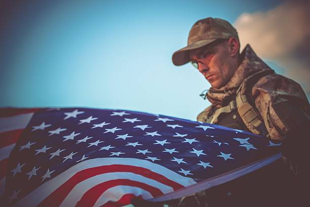 istock Army Veteran with USA Flag 530943956