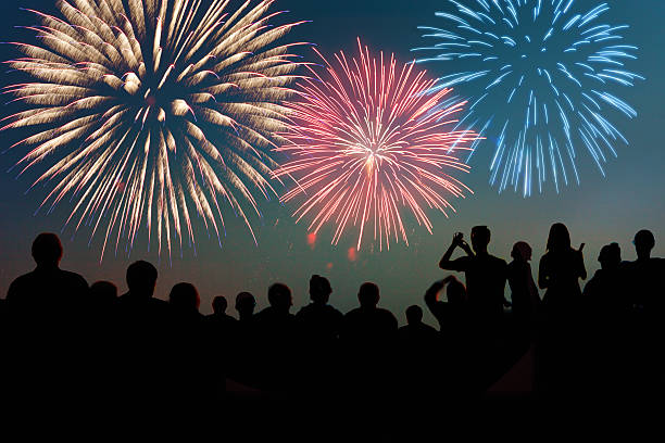 четвертого июля фейерверки взрывающаяся более зрителей в силуэт честь - new year стоковые фото и изображения