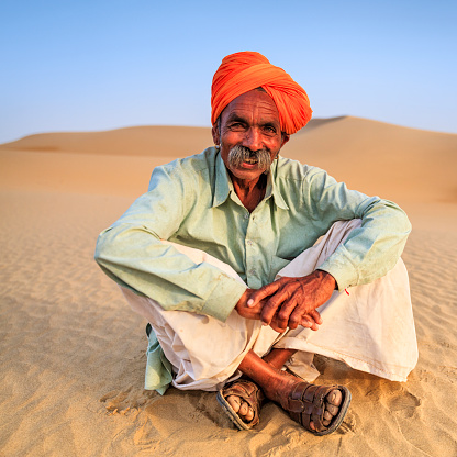 Indian man sitting on a sand dune, desert village, Rajasthan, India.http://bem.2be.pl/IS/rajasthan_380.jpg