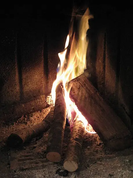Photo of Some trunks of wood burn on red, yellow flame, fire