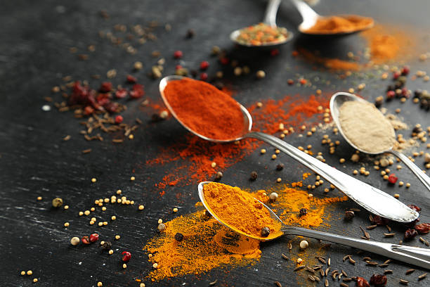 istock Spoons with spices on black wooden table 530947058