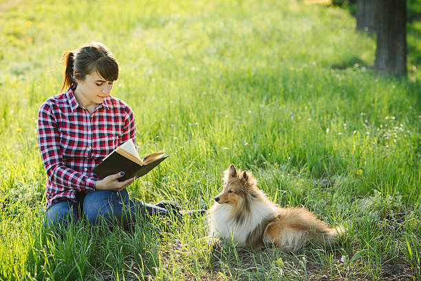 istock Student girl learning in nature with dog 530947588