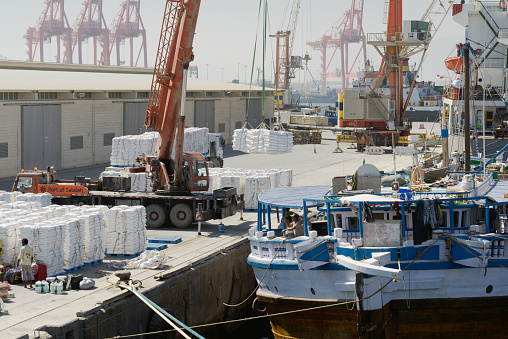 Salalah, Oman - October 21, 2014: Large harbour crane loading cargo on a vessel at the Port of Salalah