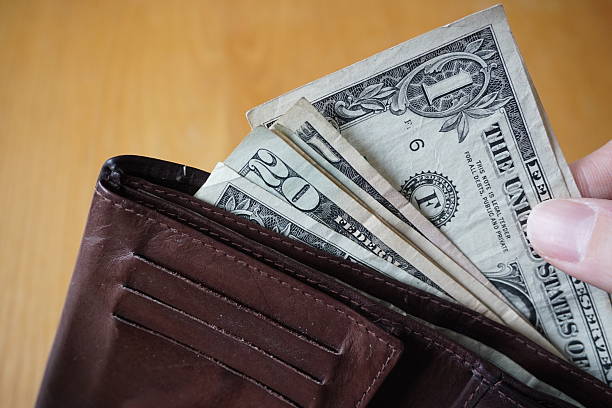 istock Male hand withdrawing American currency (US Dollars) from wallet 530947738